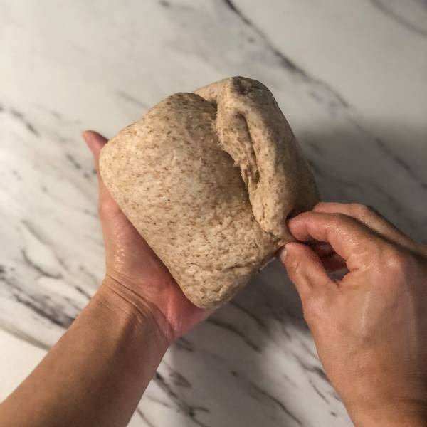 pinching the seams of the dough together