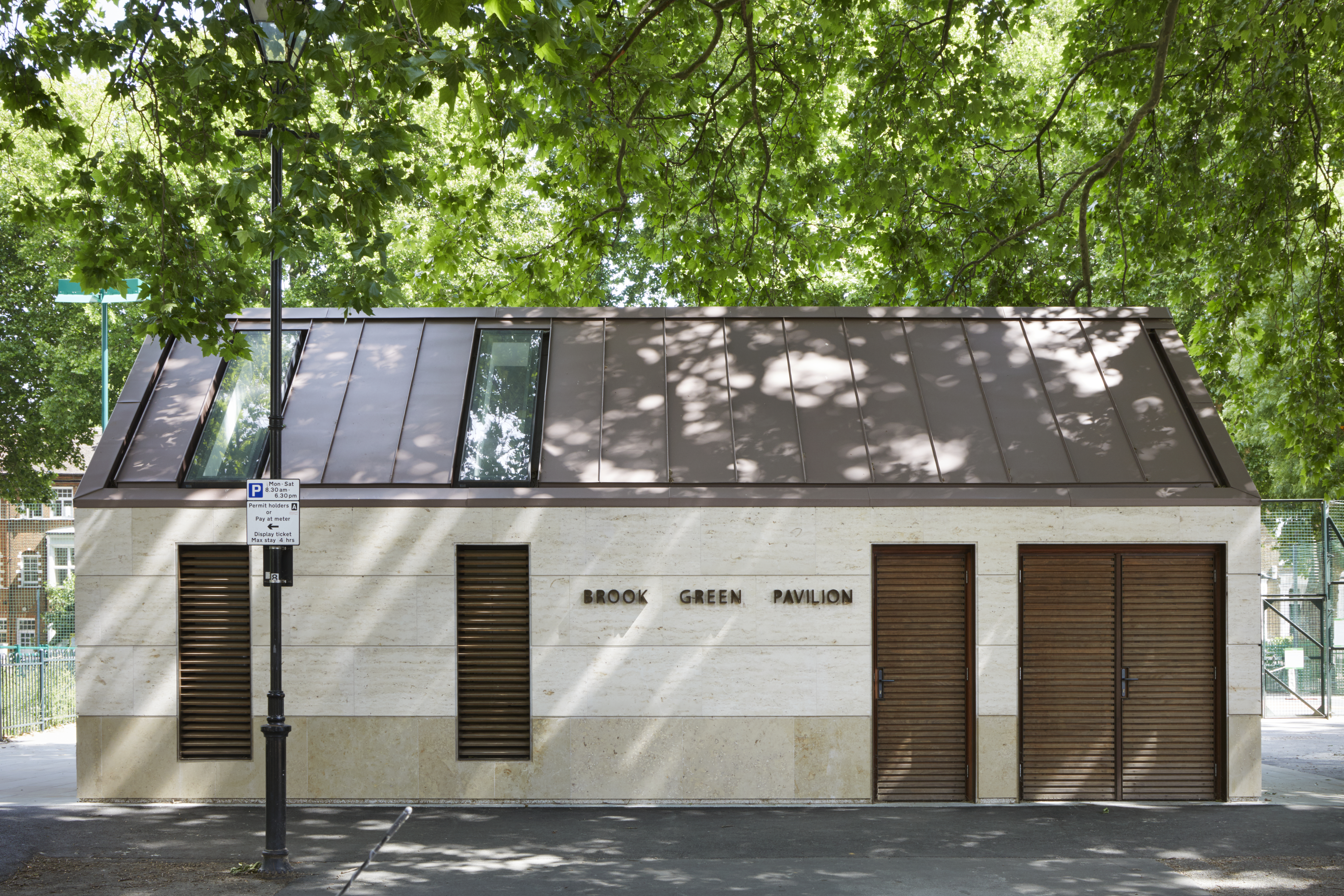 External shot of Brook Green Pavilion with leafy green branches above