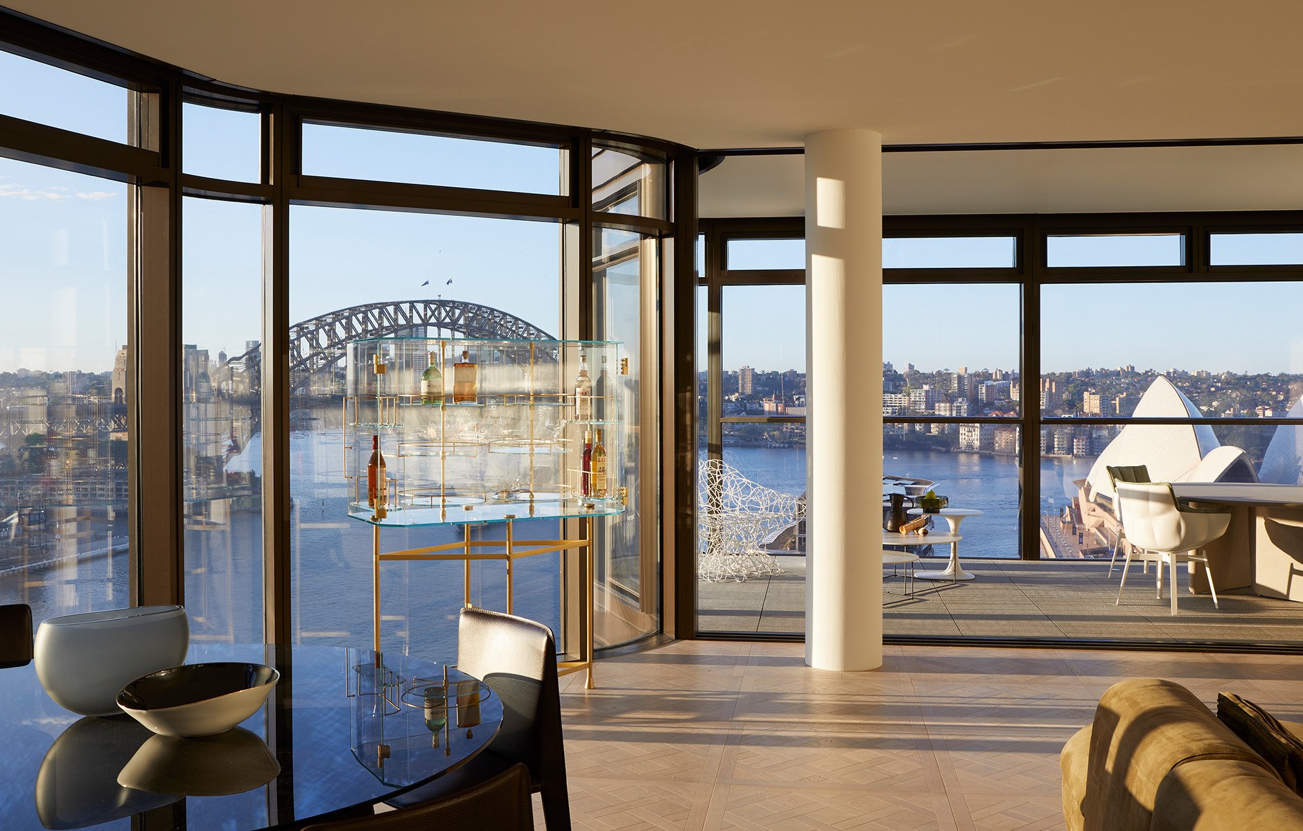 With expansive views from the city to the Harbour Bridge, Sydney Opera House and Botanic Gardens, the main living room also features the Float bar cabinet by Baxter, and the Husk outdoor chairs and Tobi-Ishi table by B&B Italia on the balcony. Photo © Martin Mischkulning.