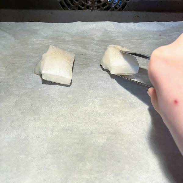 placing the mochi into the oven, flipping halfway through