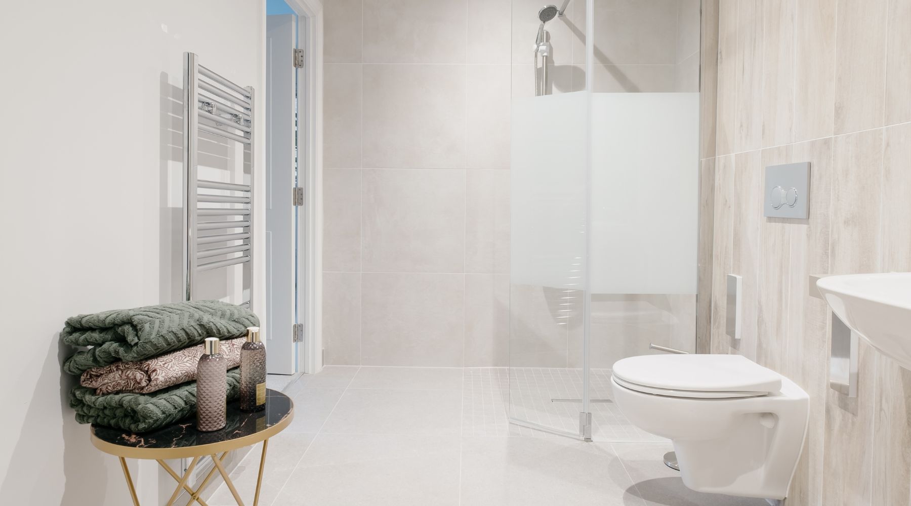 Trinity Lodge future-proofed, accessible apartment wetroom/bathroom featuring thermostatically controlled shower valve, supportive L-shaped shower riser and wall plates which enable additional grab rails to be added for extra support or to mount a shower seat onto