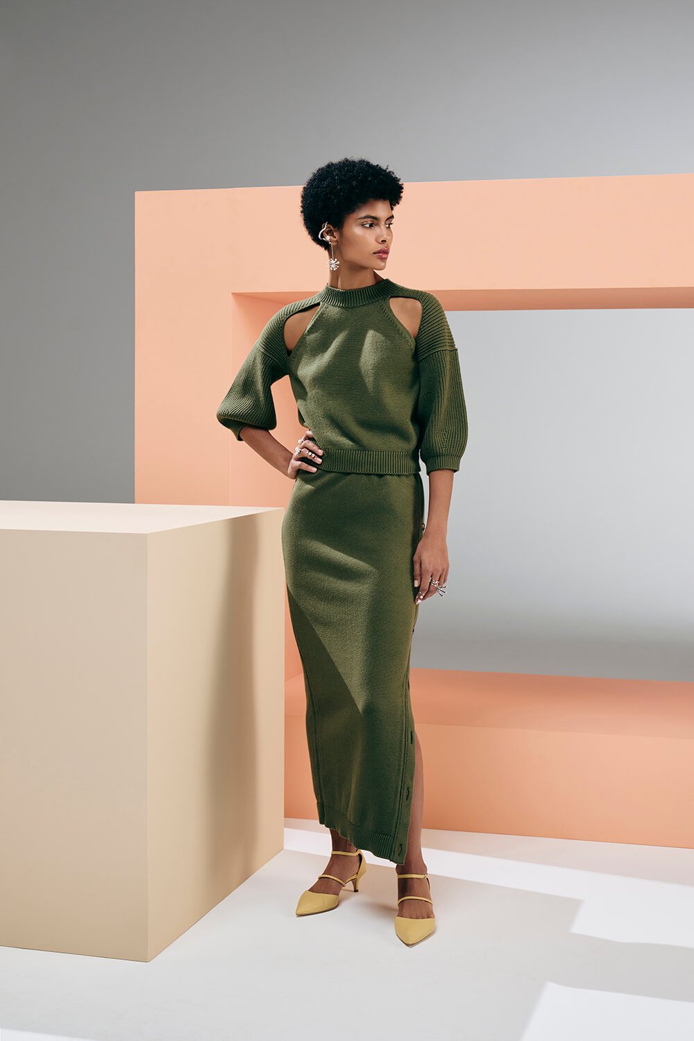 Model wears a matching set with green long knit skirt and green knit top