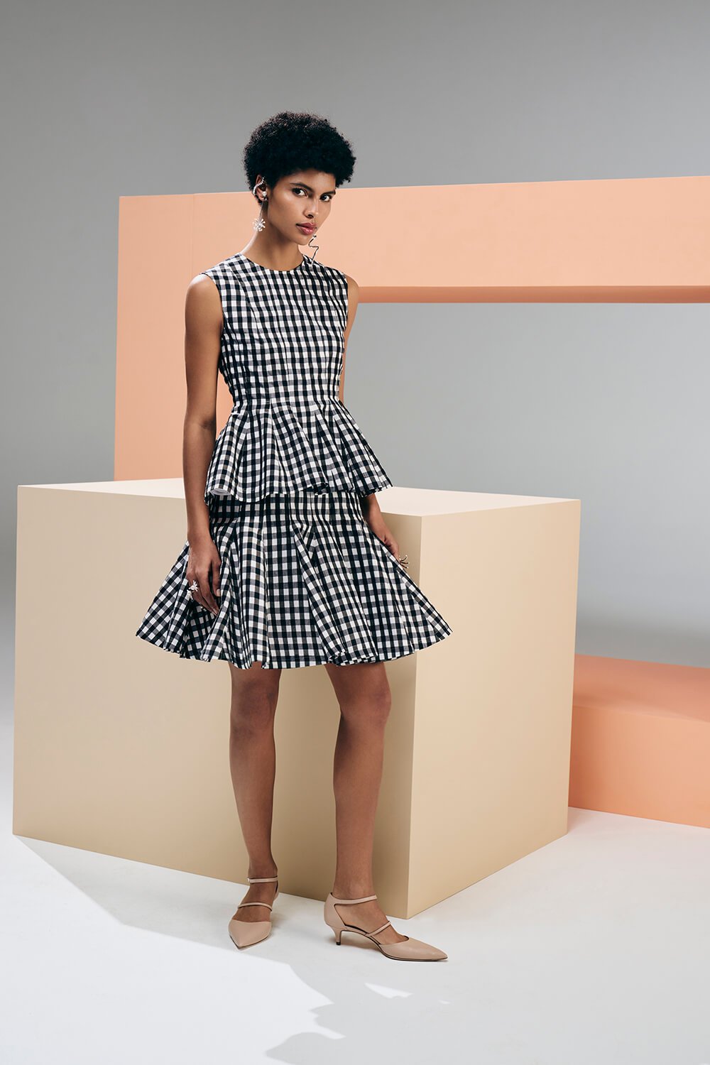 Model wears a black and white checkered skirt and top set