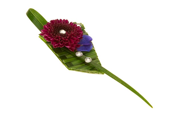 A beautiful modern prom wearable corsage is made of woven lily grass and finished with a button pom and rhinestones. 