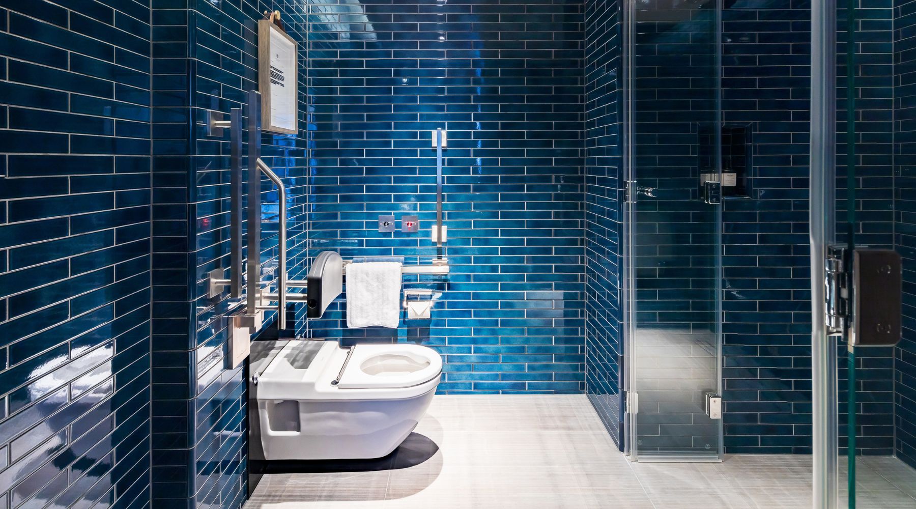 Accessible bathroom at The Londoner including grab rails and level-access shower