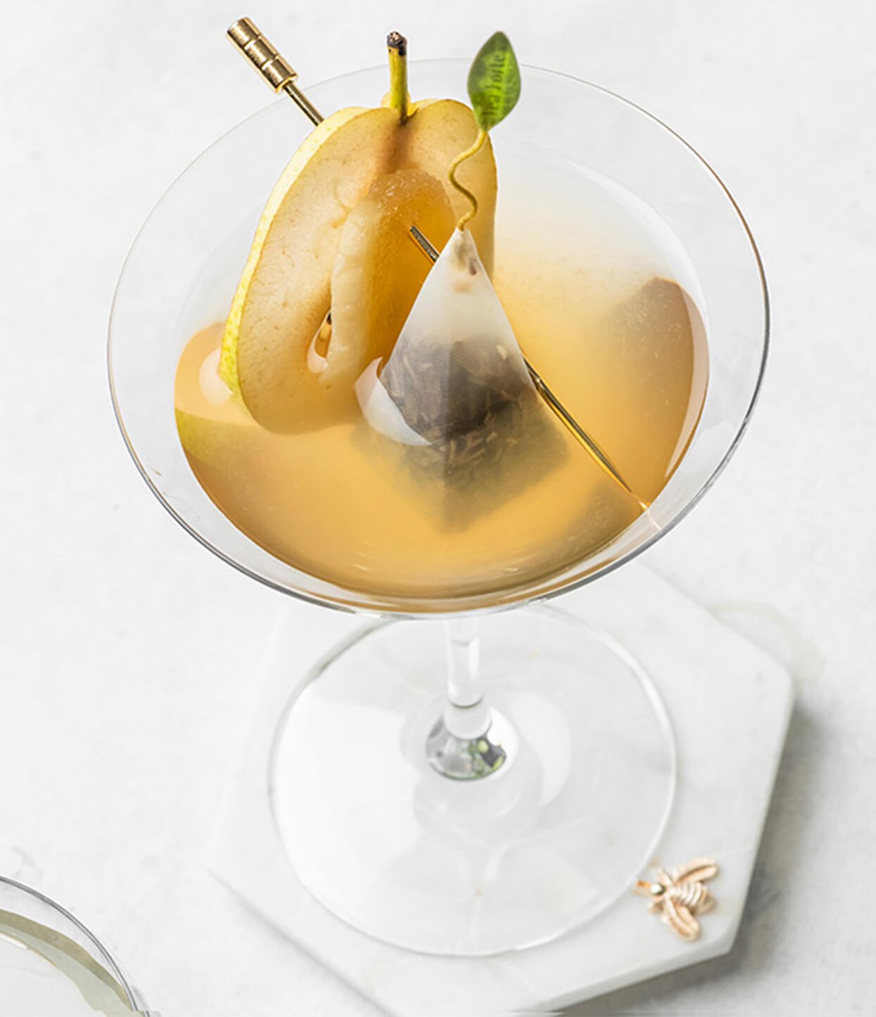 White Ginger Pear Martini in a glass with a slice of pear and infuser inside