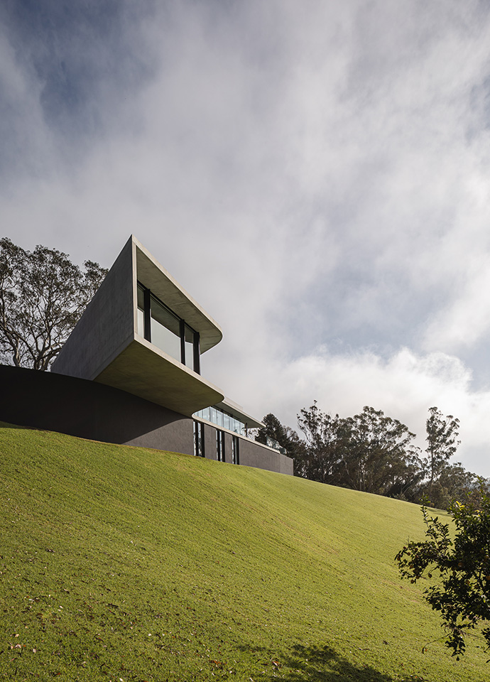 A challenging site shaped the form of the house, its sculptural projection and huge cantilever both pragmatic and artful. Photo © Cam Murchison.
