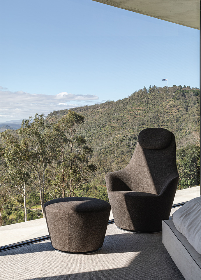 The seamless connection with nature is emphasised in the master bedroom, with breathtaking views to relax into. Featuring the Harbor armchair designed by Naoto Fukasawa for B&B Italia. Photo © Cam Murchison.