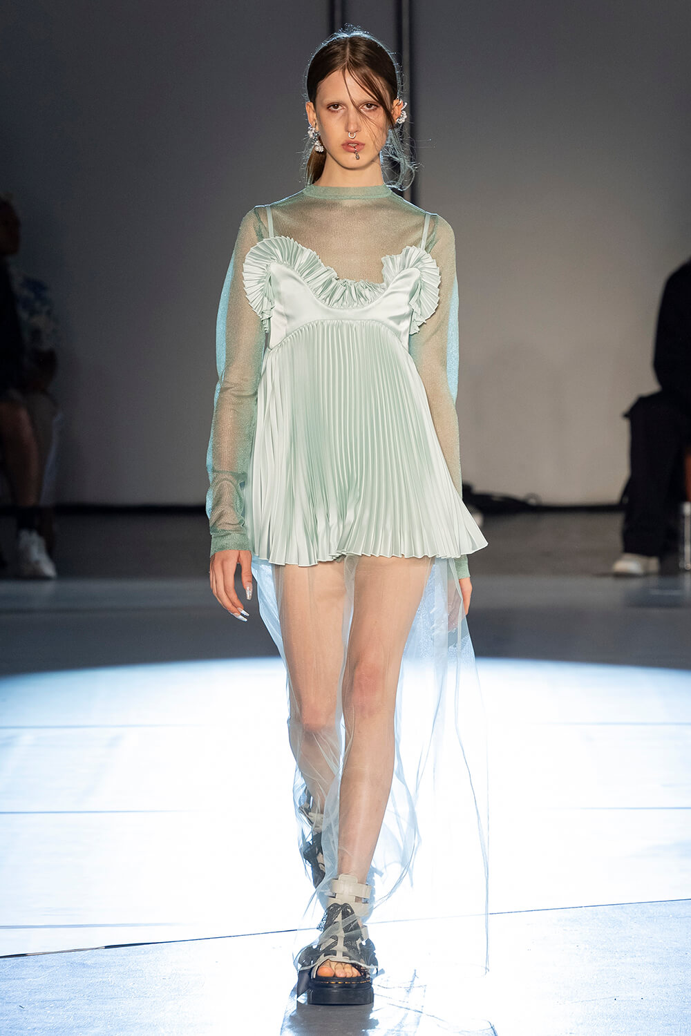 Model wears a mint colored crinkled dress and a long sleeve layer underneath
