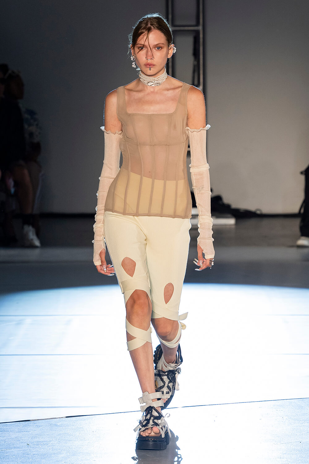 Model wears a cream corset with white lace up pants