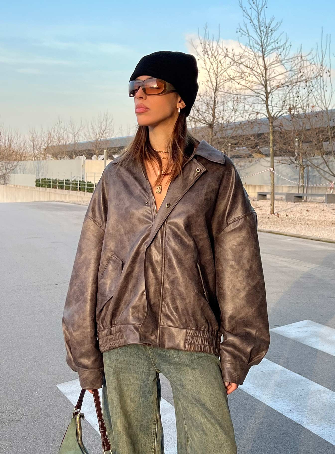woman wearing chocolate bomber jacket with wide leg jeans