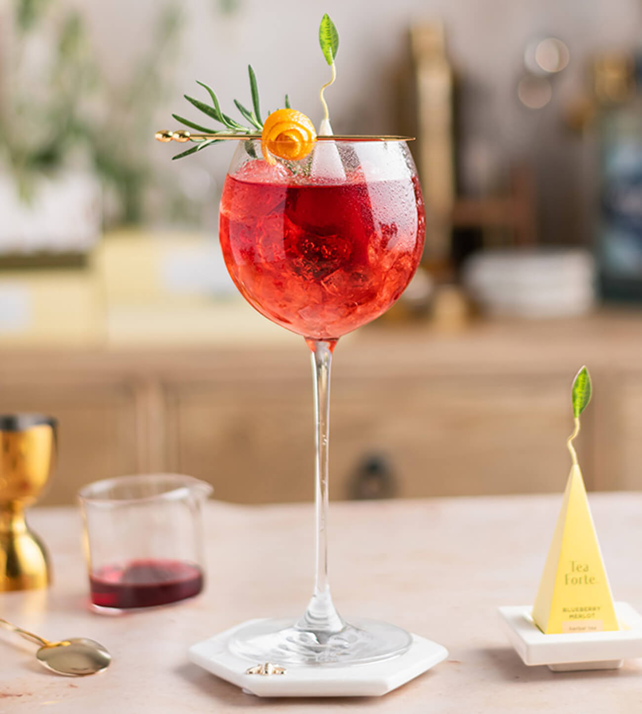 Blueberry Merlot Negroni Cocktail in a wine glass topped with an infuser and rosemary