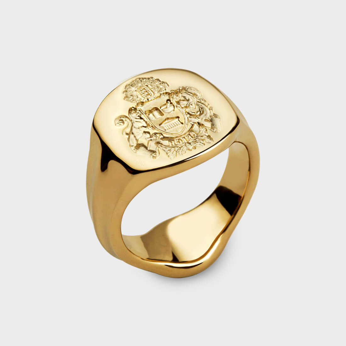 A yellow gold ring with a family crest seal engraving on it