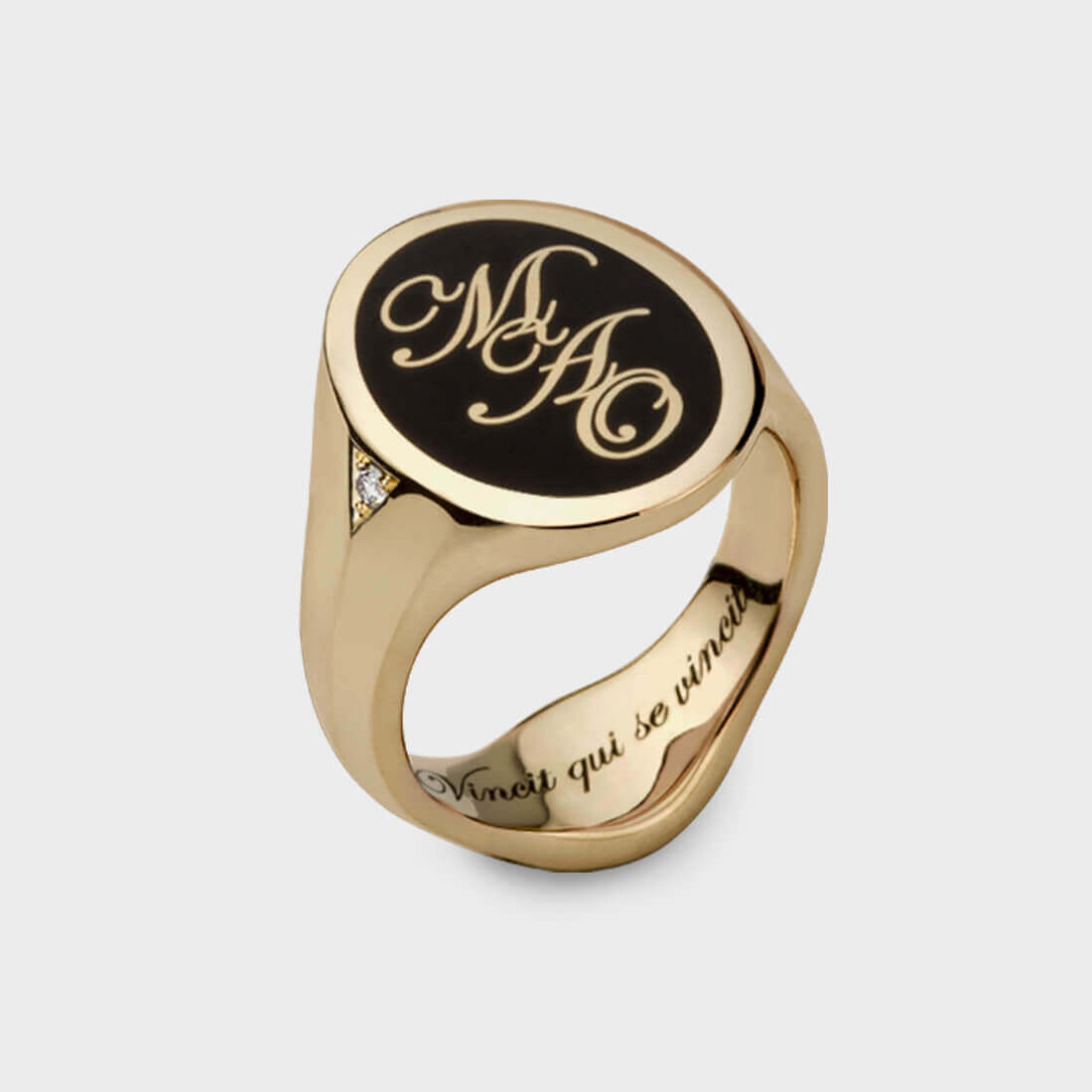 A yellow gold oval signet ring with dark blue enamel and the interlacing letters MAO engraved in yellow gold, including engraving text on the inside of the ring