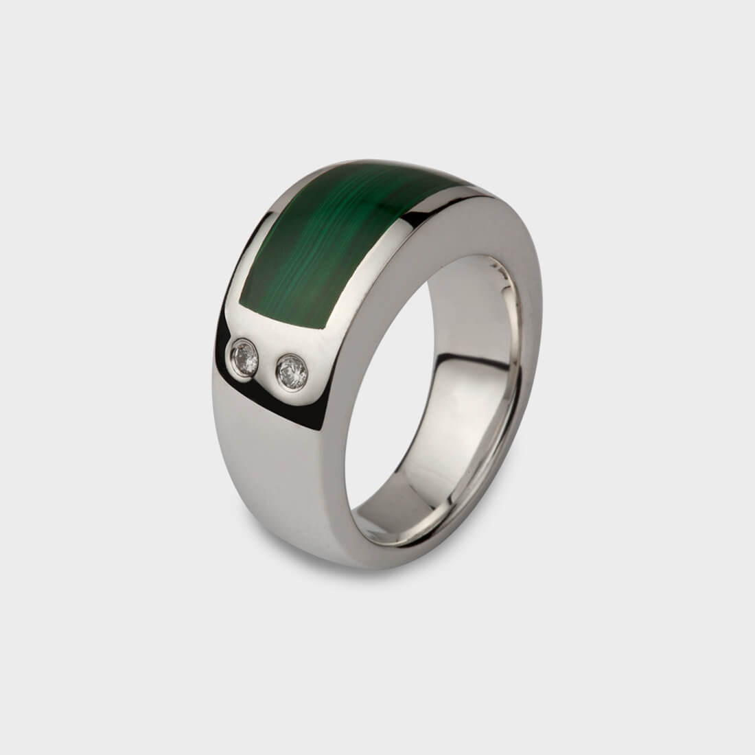 A silver signet type ring inlaid with malachite at the top and two diamonds set on the side of the ring