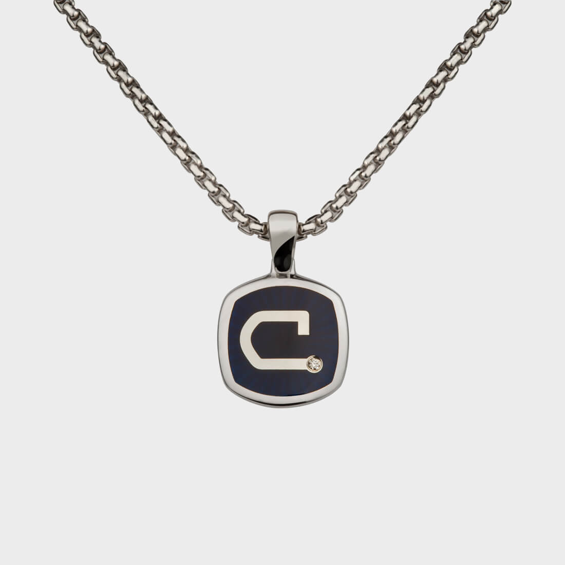 A sterling silver signet pendant inlaid with Thames wood and a 'C' letter engraved in the centre with a little diamond on