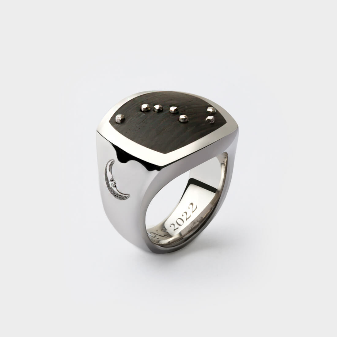 A sterling silver bespoke signet ring inlaid with Thames wood and engraved on the side with a moon design and the year 2022 on the inside bottom of the ring. Silver metal balls have been added on top of the Thames wood