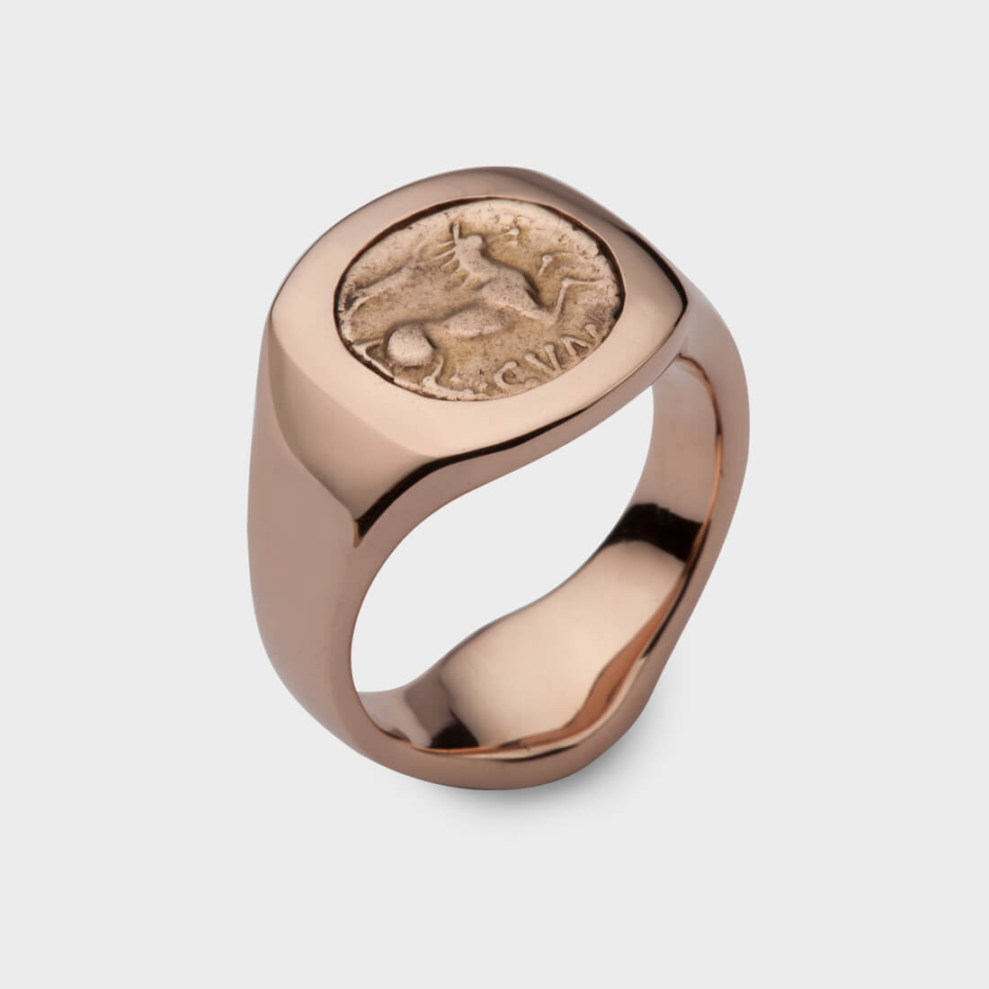 A rose gold signet ring with an ancient coin set in it
