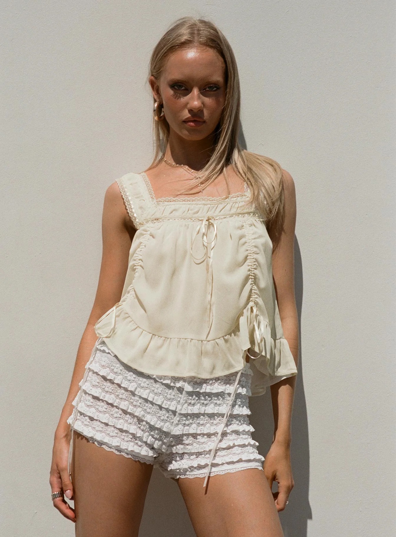 woman wearing white lace shorts with cowgirl boots