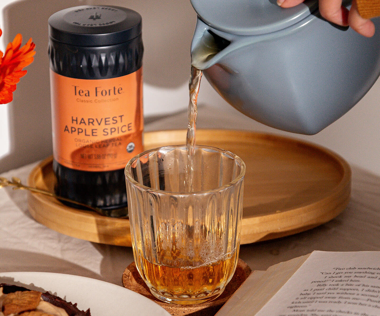Pouring a Harvest Apple Spice Sidecar into a glass with a Fiore Teapot