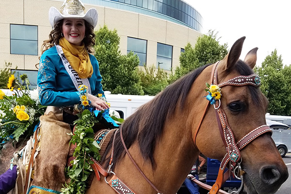 Members of an equestrian court decorate their parade horses with gorgeous floral designs on the horses' bridles, tails, and rumps. 