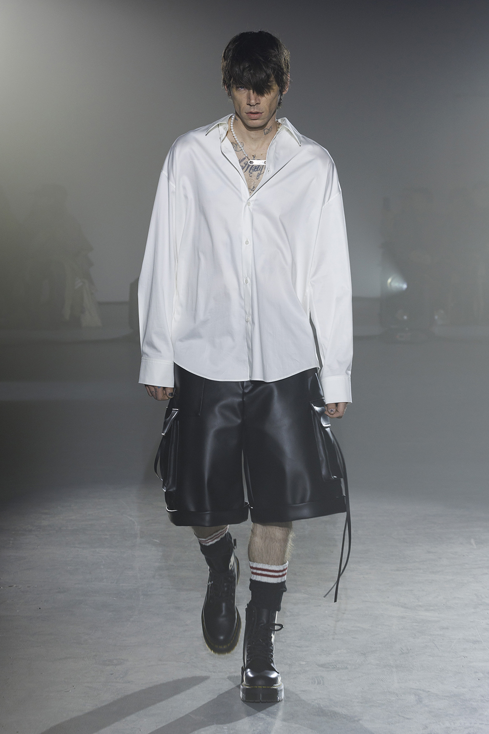 Model wears a white Botton down and black leather knee length shorts