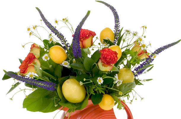 This beautiful and creative summer floral design mixes lemons, roses, feverfew, veronica, ruscus, plumosa and salal in a brightly colored Fiestaware pitcher with matching lemon and floral components.
