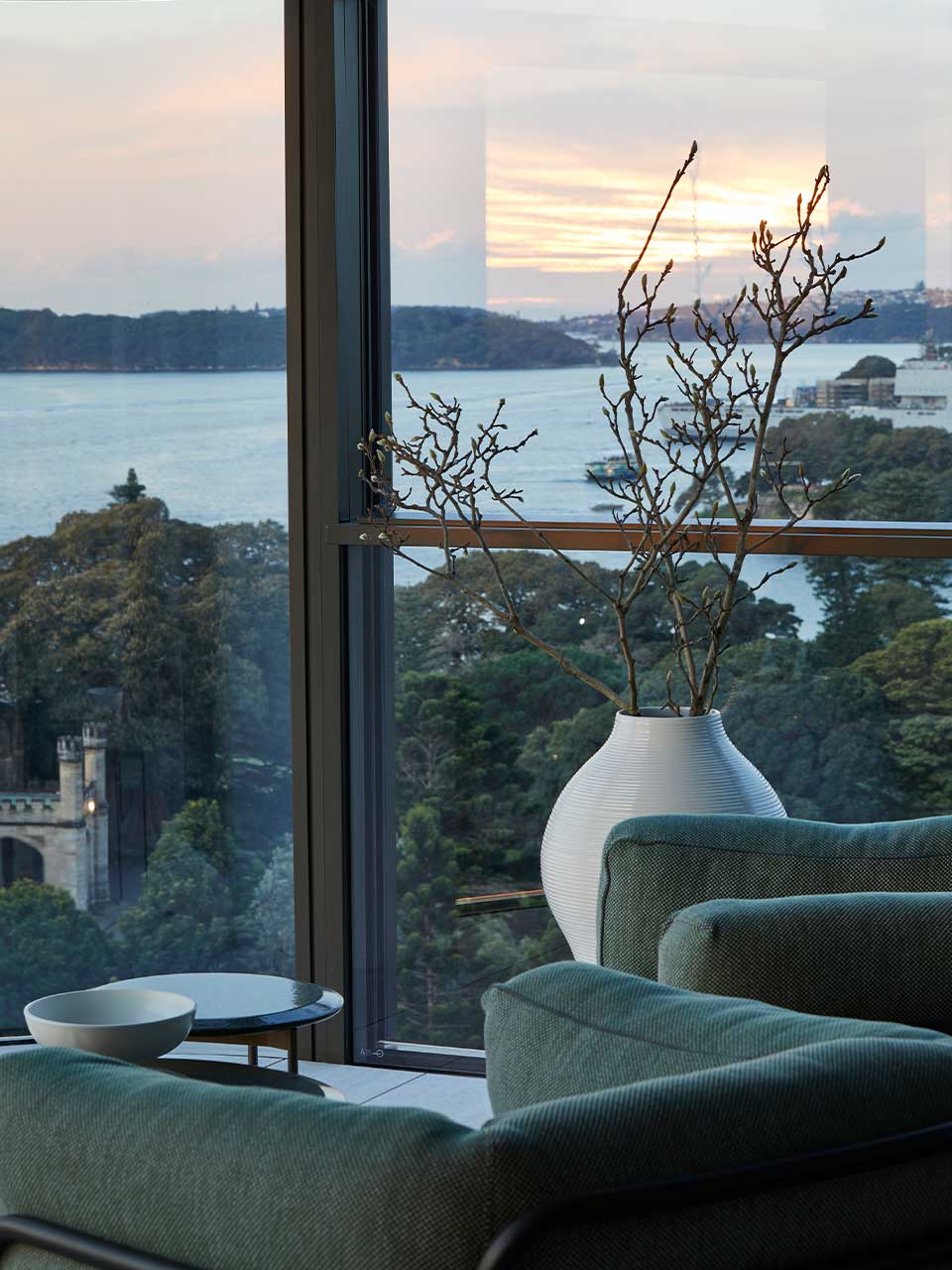 As the sun sets in the window reflection, after-work drinks are enjoyed in the B&B Italia Borea armchair.