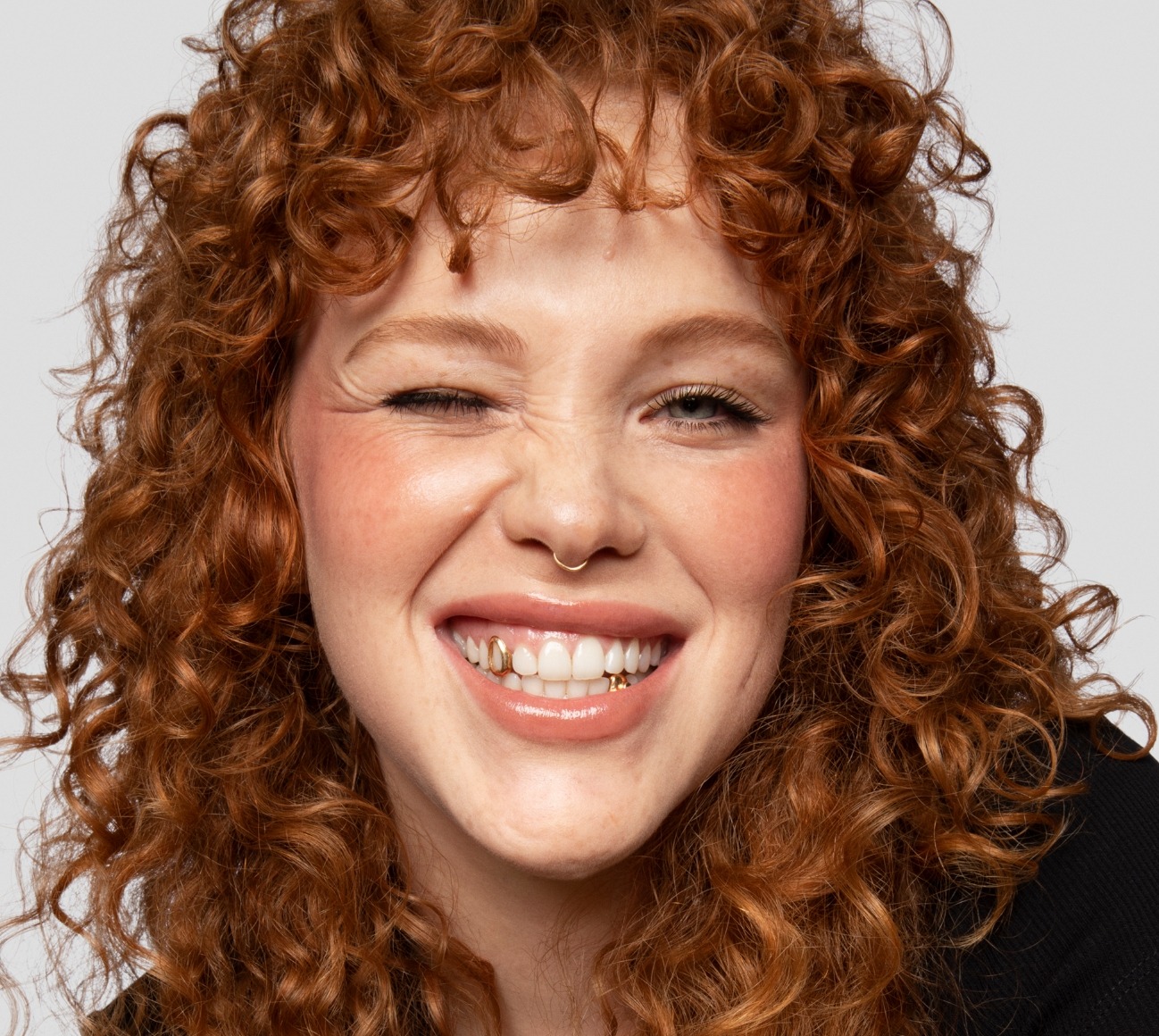 Model wears a full face of Milk Makeup products, including Lip + Cheek, KUSH Mascara, and more, against a white background.