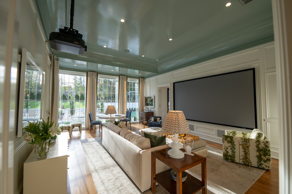 Smart home media room with projector mounted on the ceiling and projection screen on the wall