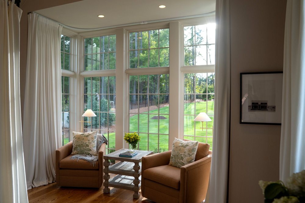 Window and drapery in a bedroom with chairs in front of the window