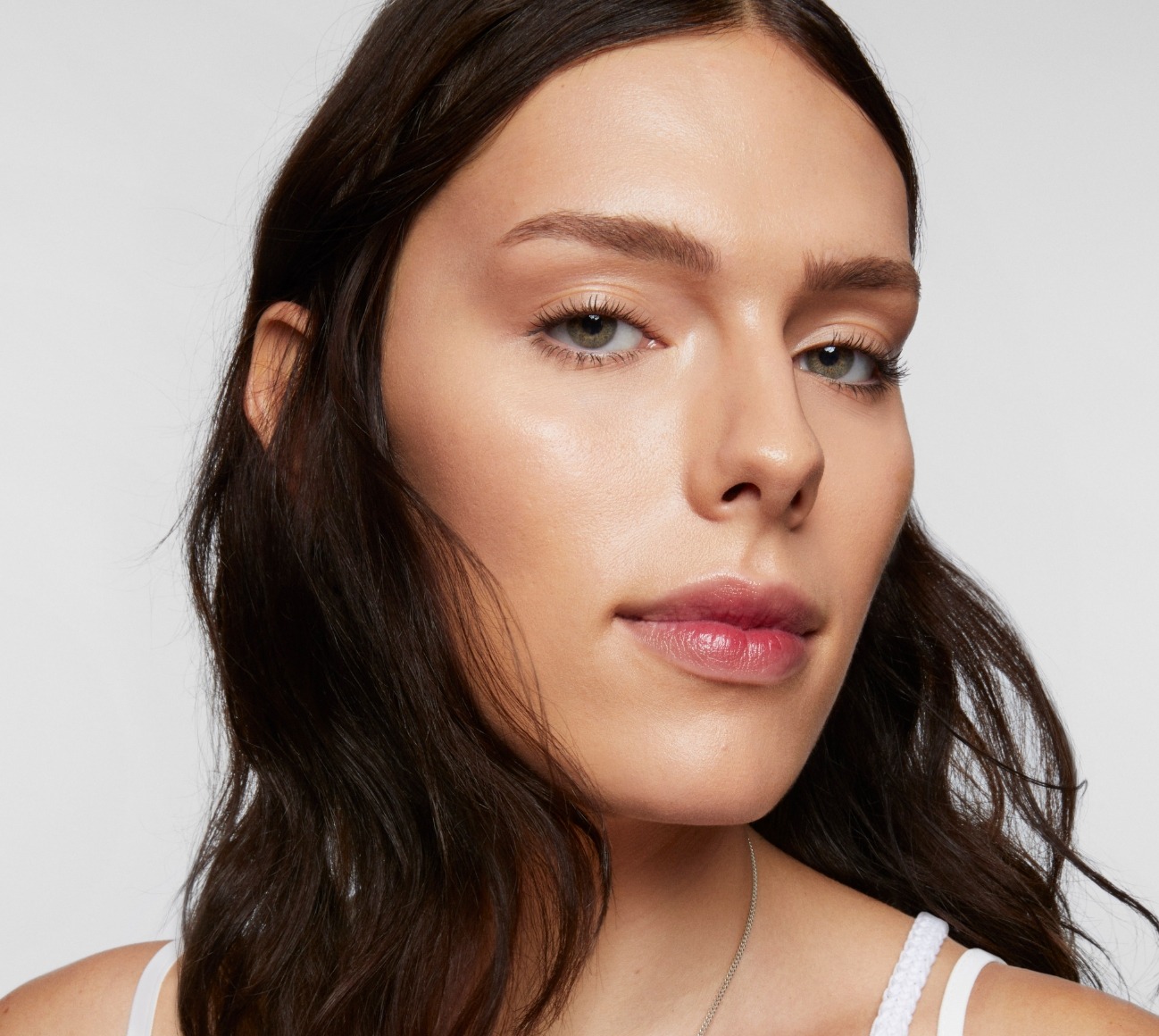 Model wears a full face of Milk Makeup Products against a white background