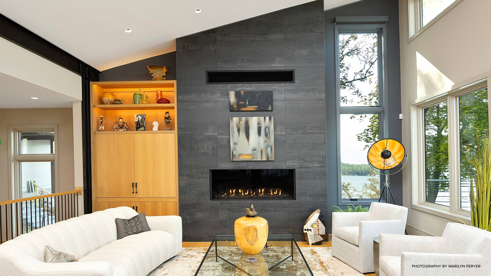 Living room in a lakehouse with white furniture and a gray fireplace