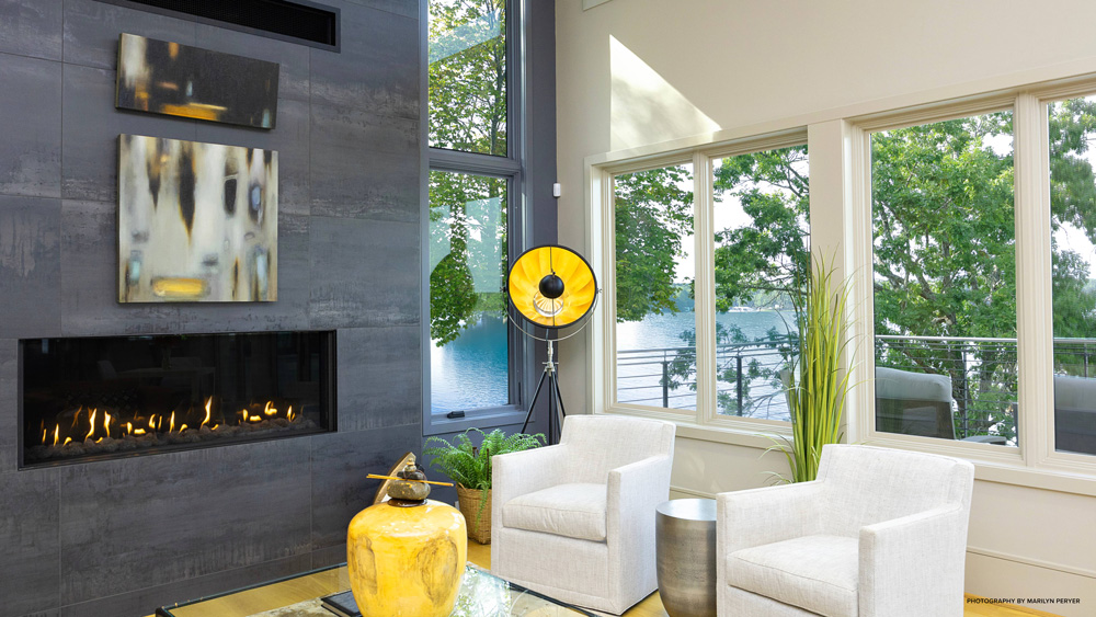 Living room in a lakehouse with white furniture and a gray fireplace