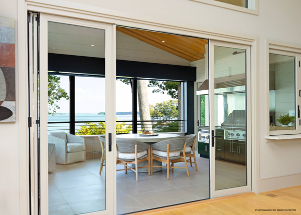 View of outdoor seating area of lakehouse through sliding doors