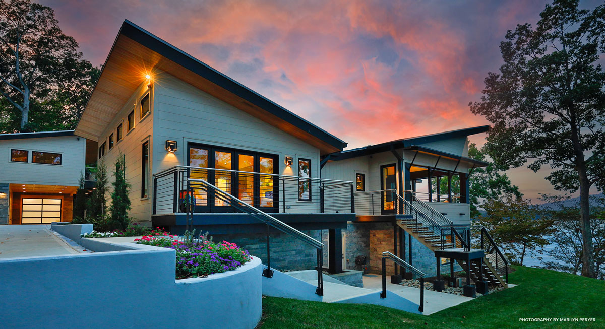 View of stairs in front of stunning lake house at sunset