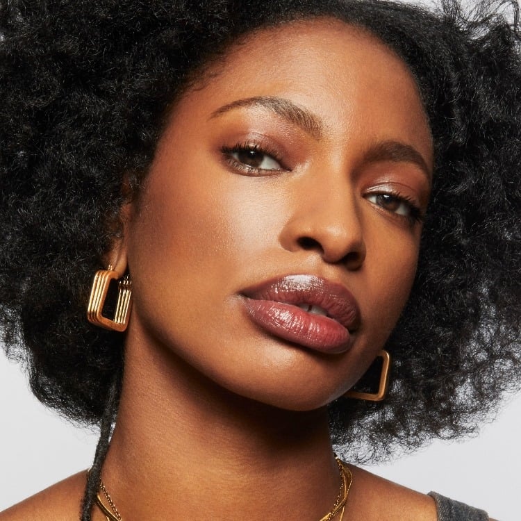 Model wears a full face of Milk Makeup Including Bionic Glow against a light gray background