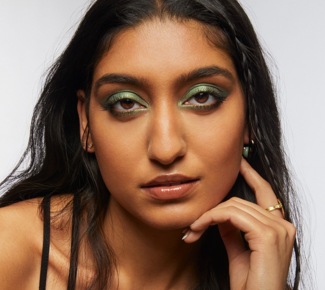 Portrait of Milk Makeup model Lizzy with smoky green eyeshadow on a white background