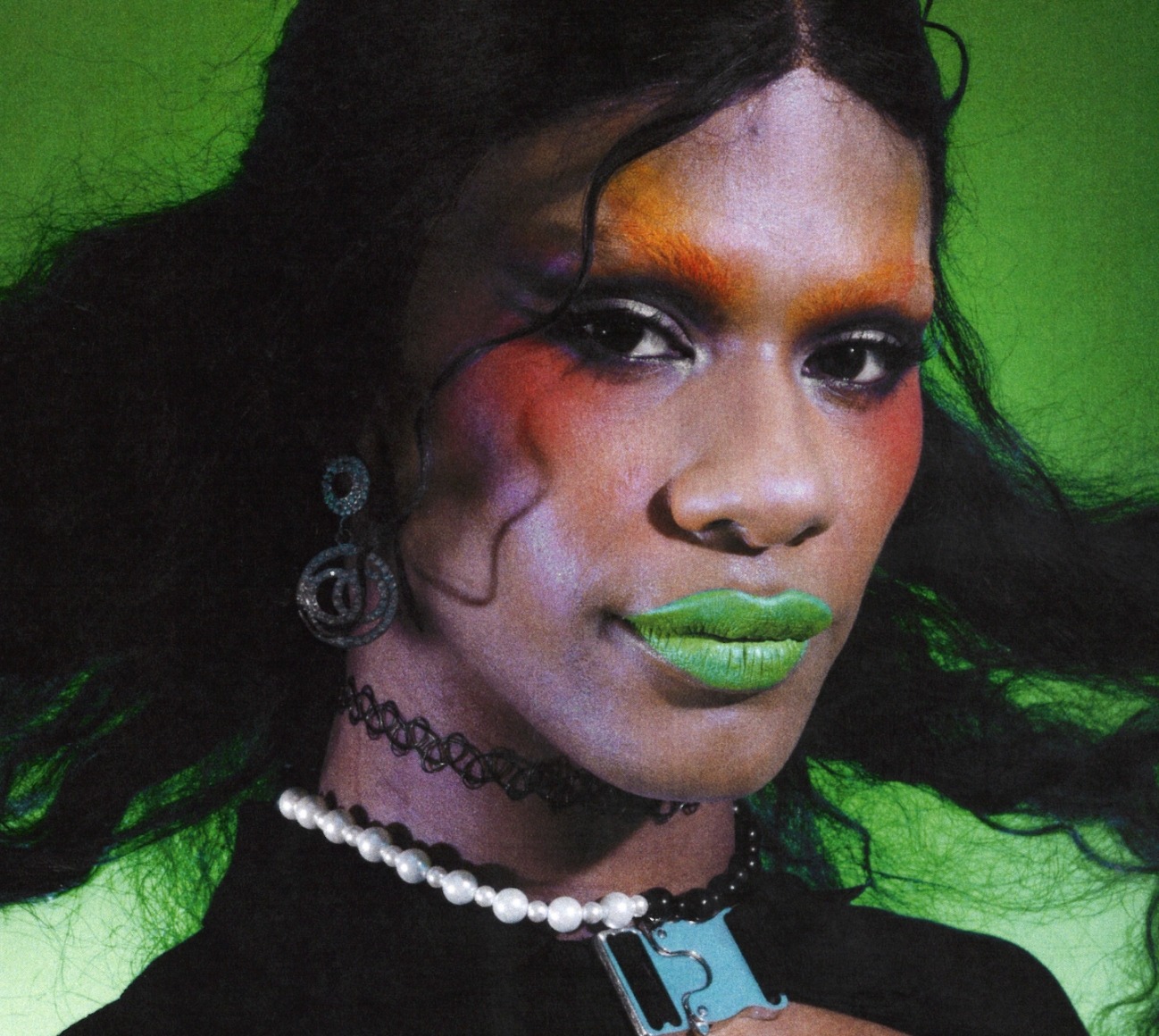 Close-up portrait of Haus of Telfar member Iris on green background