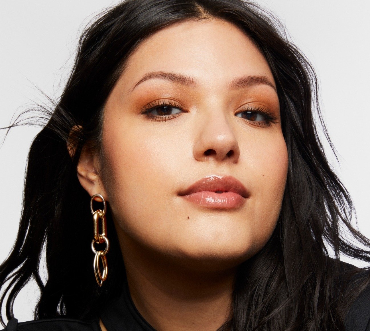 Portrait of Milk Makeup model Vanessa with a smoky warm neutral eye makeup on a white background