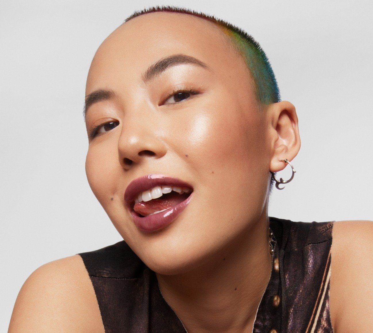 Model wears Milk Makeup Odyssey Lip Oil Gloss in Voyage on a white background