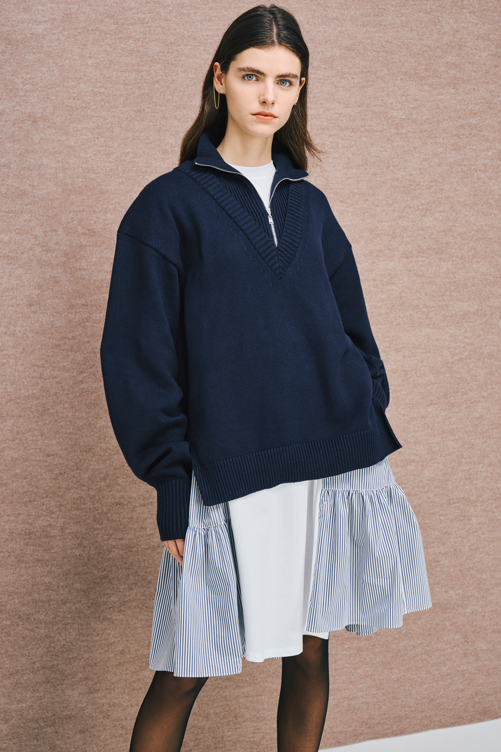 Model is wearing a navy top over a blue pinstripe dress.