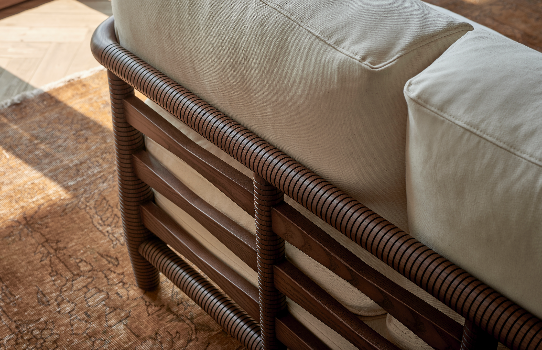 Back detail of the Gio Sofa in Dusky Pine finish with Cotton Canvas Beach Walk cushions