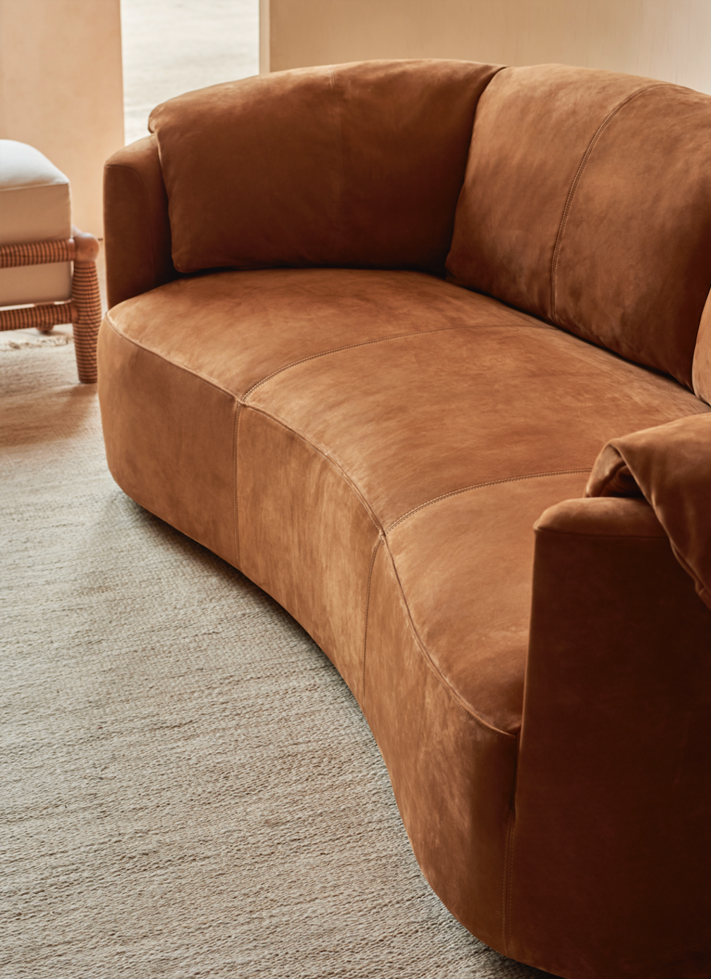 Loula Leather Sofa in Meridian Leather Sunset Canyon, placed on top of a rug