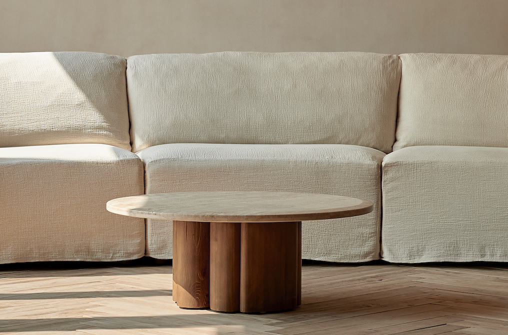 Enzo Coffee Table placed on top of a rug in front of the Loula Sectional Sofa