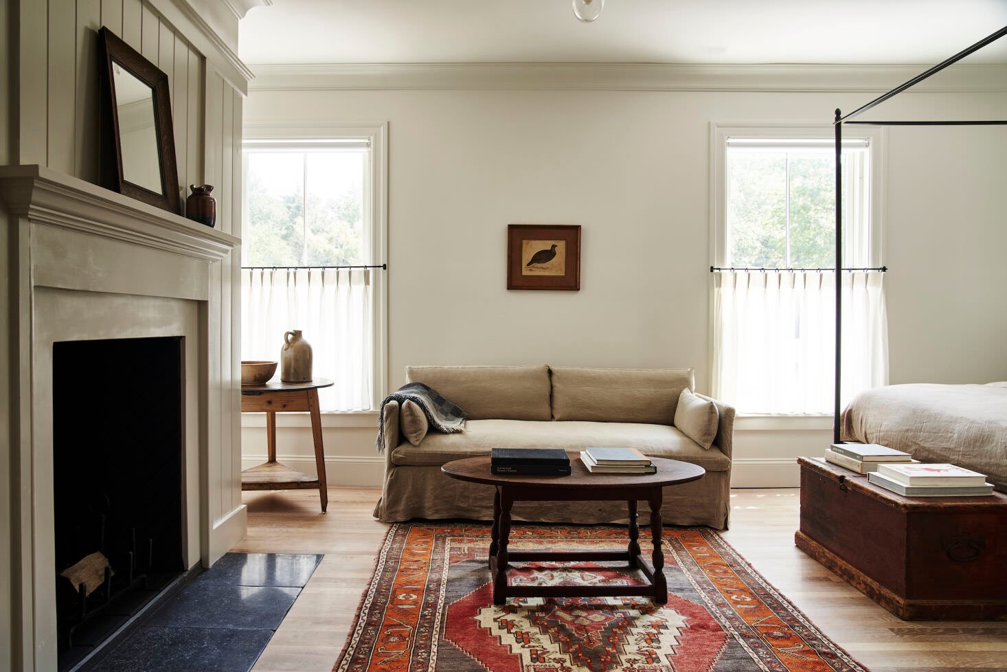 Gabriel Sofa in the center of a bedroom alongside a fireplace, coffee table, and bed