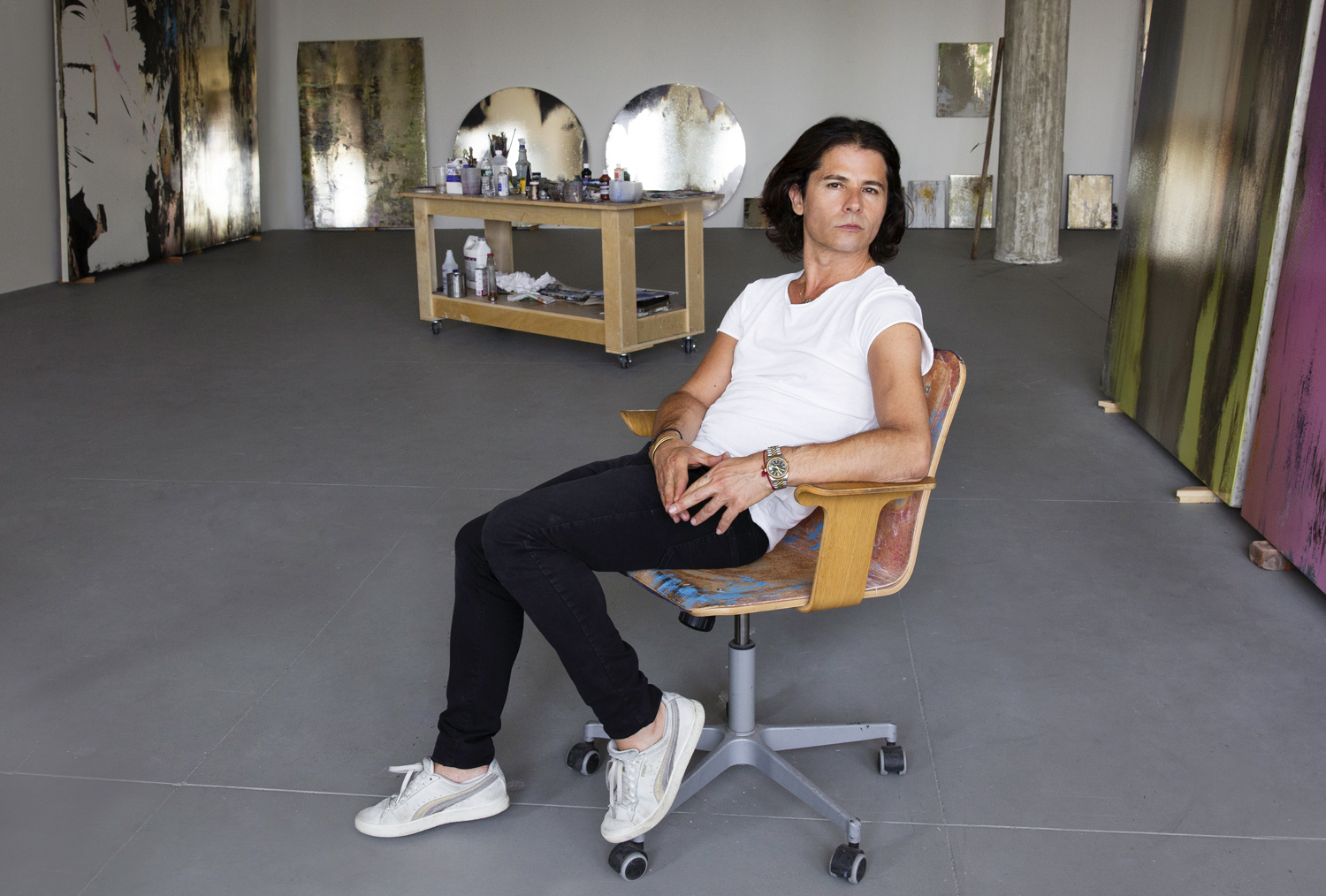 Nir Hod sits at his desk in his studio space