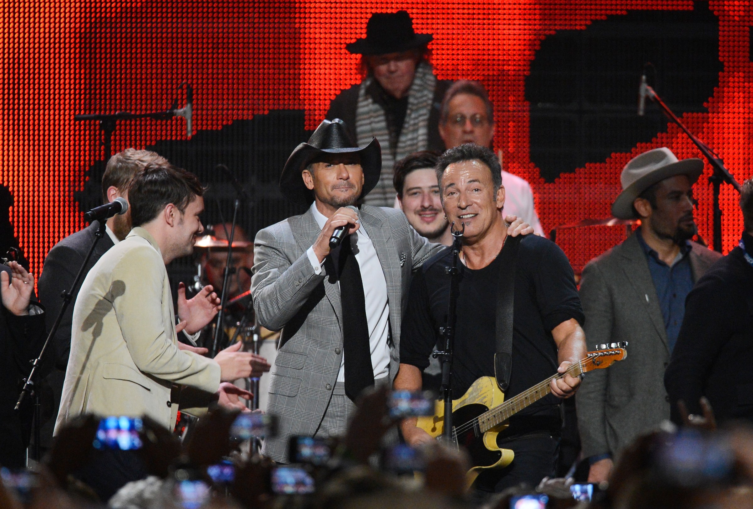 Musicians Ben Lovett, Tim McGraw, Neil Young, Marcus Mumford, drummer Max Weinberg, honoree Bruce Springsteen and singer Ben Harper perform onstage at The 2013 MusiCares Person Of The Year Gala Honoring Bruce Springsteen. Image Courtesy of Recording Academy®/Photo Kevork Djansezian by Getty Images© 2021