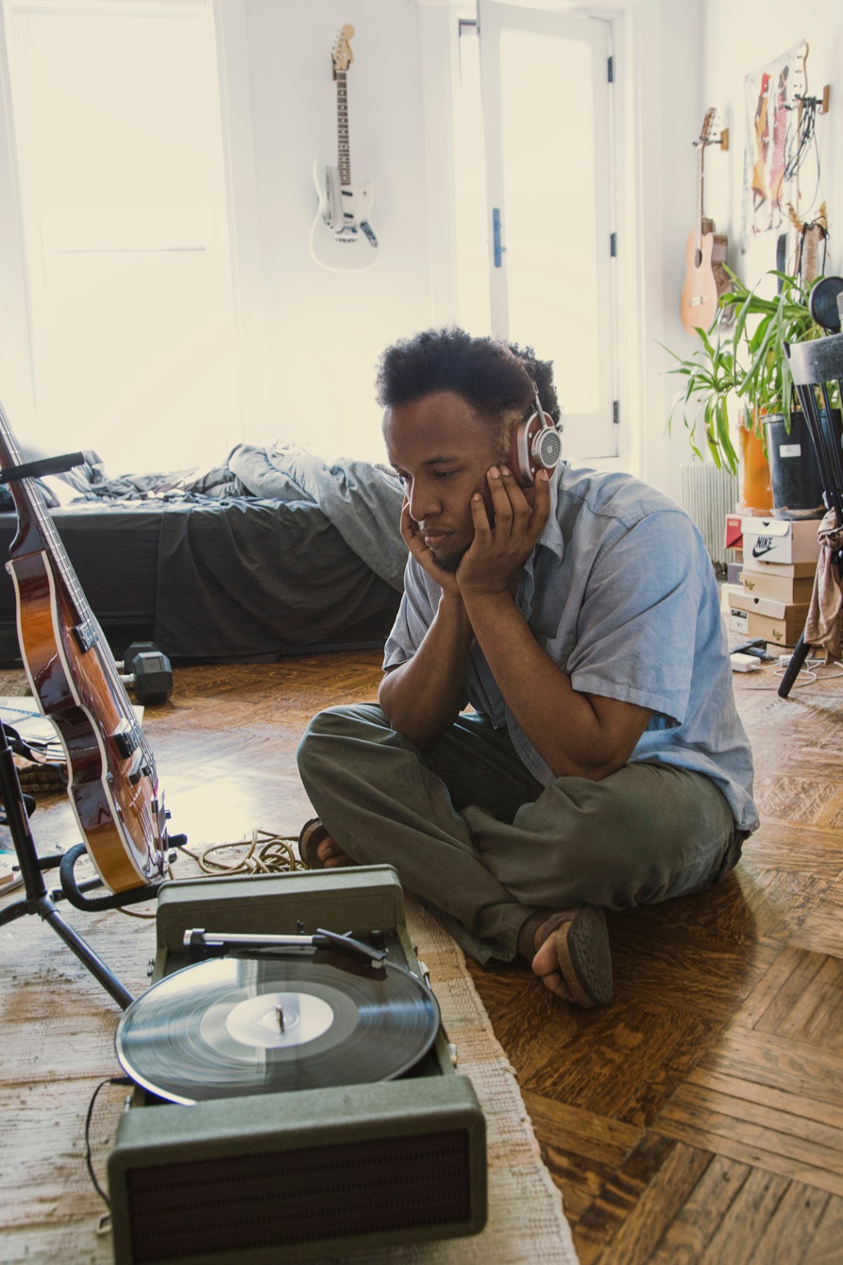 Photograph of Cautious Clay sitting on the floor wearing Master and Dynamic Headphones