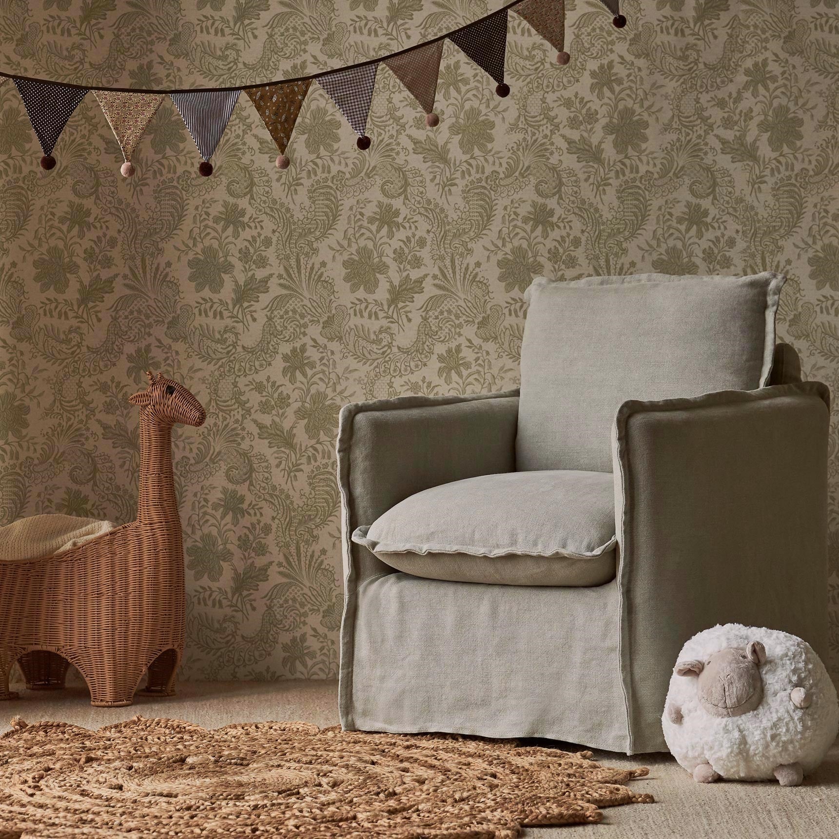 Neva Swivel Glider Chair in Jasmine Rice Medium Weight Linen, placed in a decorated room beside childrens toys